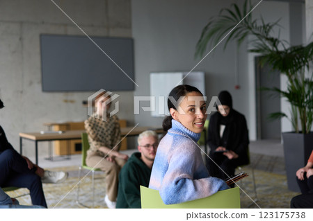 A diverse group of business professionals sits attentively in a modern office, actively participating in a training session led by an instructor, focusing on the latest technological advancements in A diverse group of business professionals sits attentively in a modern office, actively participating in a training session led by an instructor, focusing on the latest technological advancements in 123175738