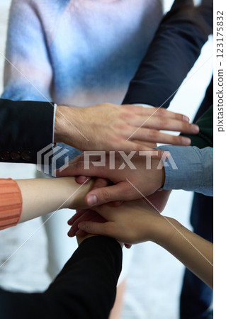 A top view of business people joining hands in a circle, symbolizing unity, collaboration, and shared success in the workplace A top view of business people joining hands in a circle, symbolizing unity, collaboration, and shared success in the workplace 123175832