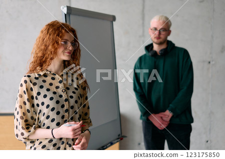 A business colleague collaboratively presenting business goals and strategies to their team in a professional office setting A business colleague collaboratively presenting business goals and strategies to their team in a professional office setting 123175850