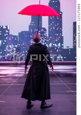 Mysterious Clown Performer with Red Umbrella in Urban Nightscape. Mysterious Clown Performer with Red Umbrella in Urban Nightscape. 123175869