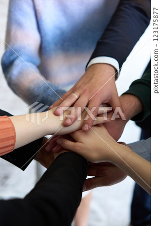 A top view of business people joining hands in a circle, symbolizing unity, collaboration, and shared success in the workplace 123175877