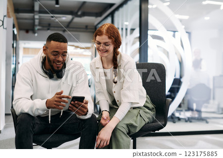 In a modern office African American businessman and businesswoman colleague, with her striking orange hair, engage in collaborative problem-solving sessions In a modern office African American businessman and businesswoman colleague, with her striking orange hair, engage in collaborative problem-solving sessions 123175885
