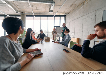 A diverse multiethnic business team engages in a collaborative meeting, discussing strategies and solutions in a modern office setting 123175976