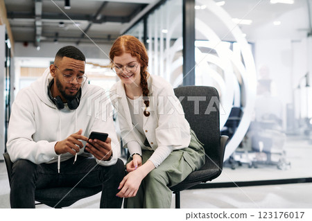 In a modern office African American businessman and businesswoman colleague, with her striking orange hair, engage in collaborative problem-solving sessions In a modern office African American businessman and businesswoman colleague, with her striking orange hair, engage in collaborative problem-solving sessions 123176017