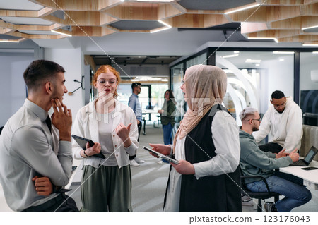 Young group of business people brainstorming together in a startup space, discussing business projects, investments, and solving challenges. 123176043