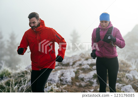 Trail running couple man and woman running on a mountain path 123176085
