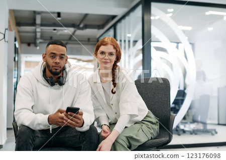 In a modern office African American businessman and businesswoman colleague, with her striking orange hair, engage in collaborative problem-solving sessions 123176098
