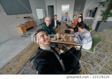A group of business professionals taking a selfie during a break in an office meeting, capturing a moment of teamwork and collaboration in a modern workplace 123176120