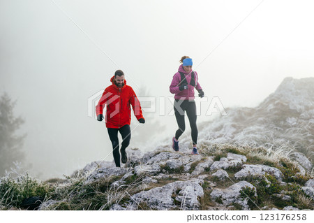 Trail running couple man and woman running on a mountain path Trail running couple man and woman running on a mountain path 123176258