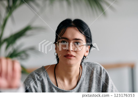 A close up portrait of a black haired businesswoman wearing glasses, captured while actively participating in a business meeting 123176353
