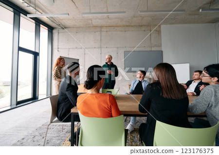 A diverse multiethnic business team engages in a collaborative meeting, discussing strategies and solutions in a modern office setting A diverse multiethnic business team engages in a collaborative meeting, discussing strategies and solutions in a modern office setting 123176375