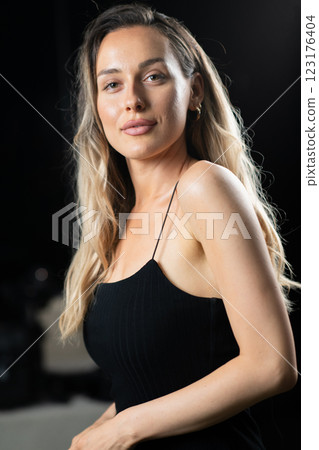 Radiant Elegance: A Stunning Blonde in a Black Dress Exuding Confidence and Beauty. 123176404