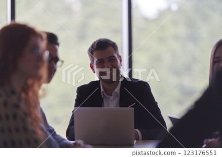 A diverse multiethnic business team engages in a collaborative meeting, discussing strategies and solutions in a modern office setting A diverse multiethnic business team engages in a collaborative meeting, discussing strategies and solutions in a modern office setting 123176551