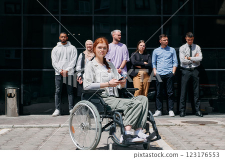 A diverse and confident group of businessmen posing together, with a businesswoman in a wheelchair radiating success, ambition, and unity, capturing the essence of a dynamic and inspiring business A diverse and confident group of businessmen posing together, with a businesswoman in a wheelchair radiating success, ambition, and unity, capturing the essence of a dynamic and inspiring business 123176553