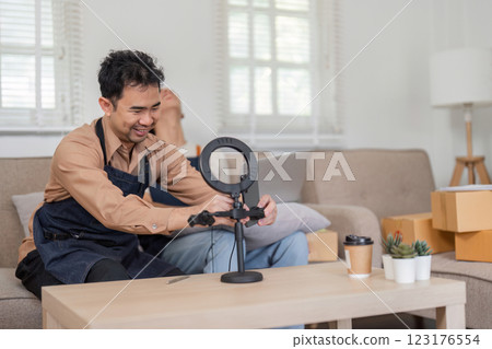 Online seller setting up a ring light for video content creation at home. Online seller setting up a ring light for video content creation at home. 123176554