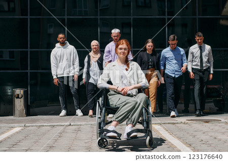 A diverse and confident group of businessmen posing together, with a businesswoman in a wheelchair radiating success, ambition, and unity, capturing the essence of a dynamic and inspiring business 123176640