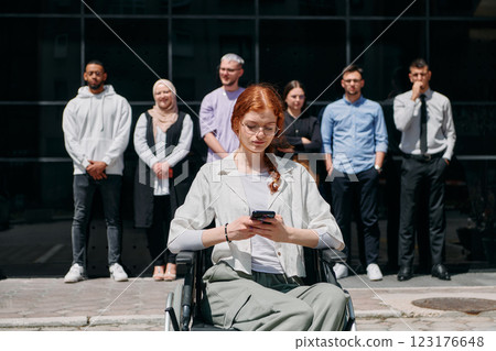A diverse and confident group of businessmen posing together, with a businesswoman in a wheelchair radiating success, ambition, and unity, capturing the essence of a dynamic and inspiring business 123176648