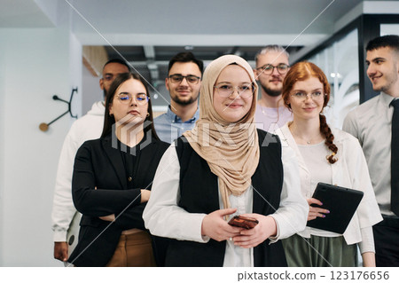 A group of business professionals standing together, taking a well-deserved break from their busy workday, showcasing camaraderie, teamwork, and a moment of relaxation in their dynamic workplace 123176656