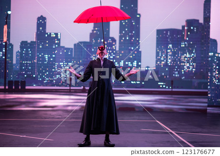 Mysterious Clown Performer with Red Umbrella in Urban Nightscape. Mysterious Clown Performer with Red Umbrella in Urban Nightscape. 123176677