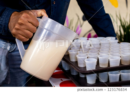 Traditional pulque drink. Tourist guide showing the importance of the agave plant for the antique cultures to a group of tourists at the Teotihuacan archaeological site. 123176834