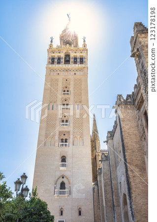 The Giralda bell tower of The Seville Cathedral, The Cathedral of Saint Mary of the See in Seville town, Andalusia, Spain, Europe. Tall, ornate tower of a historic cathedral bathed in sunlight. The Giralda bell tower of The Seville Cathedral, The Cathedral of Saint Mary of the See in Seville town, Andalusia, Spain, Europe. Tall, ornate tower of a historic cathedral bathed in sunlight. 123178198