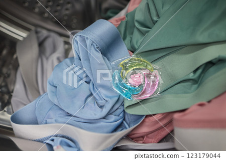 Using Laundry Detergent Pods While Doing Laundry in the Washing Machine with Clothes 123179044