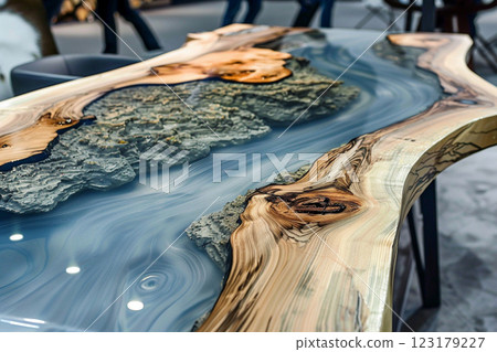Epoxy resin wood table with blue design, showcasing intricate details and natural wood textures in a modern interior . 123179227
