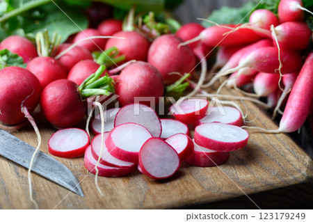 Close-up of fresh organic pink radish being sliced on a wooden board 123179249