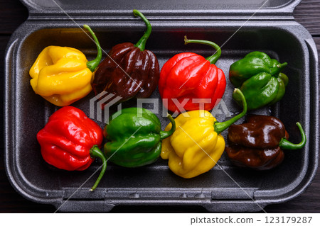 Ripened multicolored habanero peppers in plastic box Ripened multicolored habanero peppers in plastic box 123179287