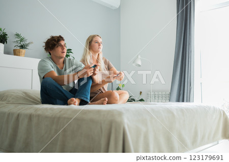 Young couple having fun at home playing video games. Technologies and gaming concept 123179691