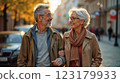 Happy European senior couple in love walking together in city streets on sunny summer evening 123179933