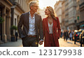 Happy European senior couple in love walking together in city streets on sunny summer evening 123179938