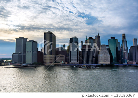 Manhattan skyline showcases mix of modern historic buildings under cloudy sky at dusk along waterfront NYC America Manhattan skyline showcases mix of modern historic buildings under cloudy sky at dusk along waterfront NYC America 123180367