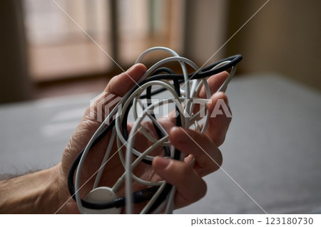 Tangled Cords in Hand The Everyday Clutter and Chaos of Our Modern Technology Life Tangled Cords in Hand The Everyday Clutter and Chaos of Our Modern Technology Life 123180730