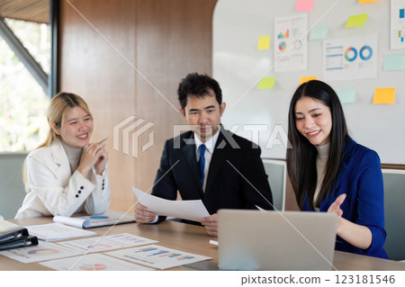 Engaged diverse business team discussing financial reports and strategies in a modern office setting. 123181546