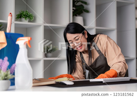 Housekeeper cleaning home office modern workspace image of a maid in action indoor environment close up view concept of cleanliness Housekeeper cleaning home office modern workspace image of a maid in action indoor environment close up view concept of cleanliness 123181562