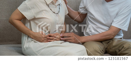 Elderly couple addressing abdominal discomfort, highlighting compassion and care in their relationship. 123181567