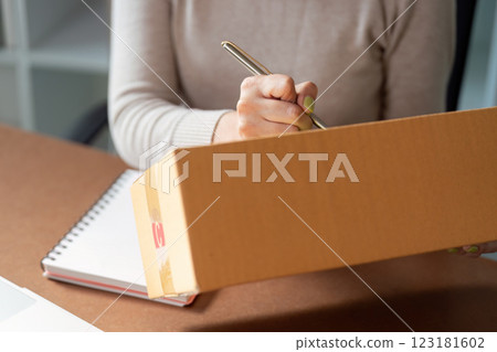 Muslim woman managing online sales while talking on the phone in a home office setting. Muslim woman managing online sales while talking on the phone in a home office setting. 123181602