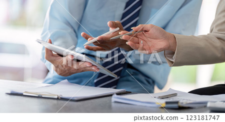 Business professionals collaborating on financial analysis and strategy using digital devices and documents. 123181747