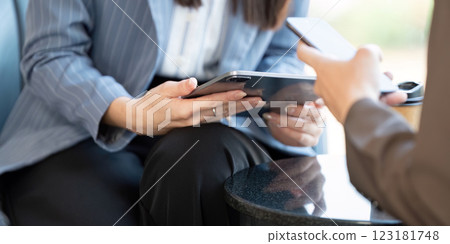 Close-up of business professionals collaborating on project plans using digital devices in a modern office. Close-up of business professionals collaborating on project plans using digital devices in a modern office. 123181748