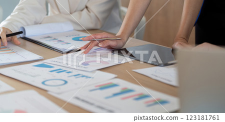 Business team analyzing data reports and charts during a meeting, focusing on project performance and strategy development. 123181761