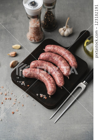 Uncooked grilled sausages on the cutting board 123182191