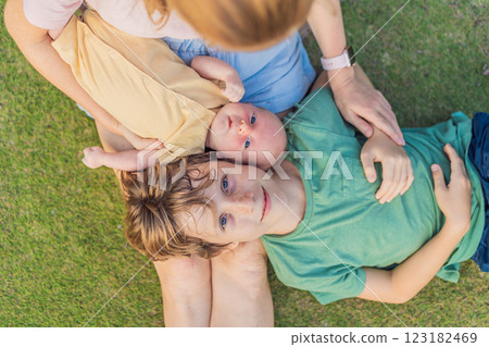 Young mother, teenage son, and one-month-old baby enjoying quality family time in the park. Multigenerational bonding and outdoor family love concept Young mother, teenage son, and one-month-old baby enjoying quality family time in the park. Multigenerational bonding and outdoor family love concept 123182469