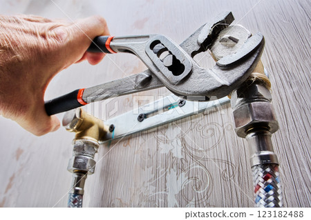Plumber is installing pipe plug using adjustable pliers. 123182488