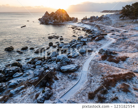 Aerial view of the snowy Nakasuka coast in Aomori Prefecture, bathed in orange light by the morning sun; Tanesashi Coast, Hachinohe City Aerial view of the snowy Nakasuka coast in Aomori Prefecture, bathed in orange light by the morning sun; Tanesashi Coast, Hachinohe City 123182554