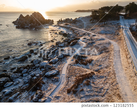 Aerial view of the snowy Nakasuka coast in Aomori Prefecture, bathed in orange light by the morning sun; Tanesashi Coast, Hachinohe City Aerial view of the snowy Nakasuka coast in Aomori Prefecture, bathed in orange light by the morning sun; Tanesashi Coast, Hachinohe City 123182555