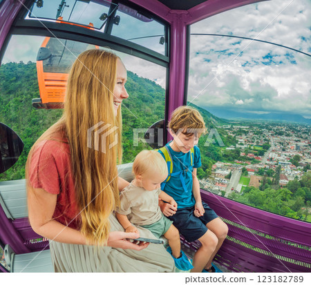 Mother and two sons on a cable car ride in Orizaba, Mexico. Scenic family adventure with panoramic views of the city, lush mountains, and iconic landscapes. Concept of family bonding, travel, and 123182789