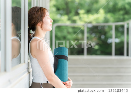 Healthy woman holding a yoga mat (yoga instructor/yogini) 123183443