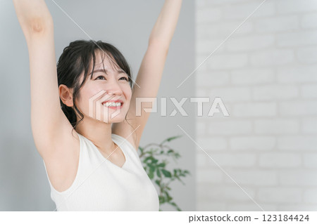 一位微笑的亞洲女性,穿著無袖服裝,進行美容、皮膚護理、脫毛和美學圖像 一位微笑的亞洲女性,穿著無袖服裝,進行美容、皮膚護理、脫毛和美學圖像 123184424