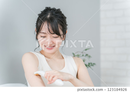 Asian woman using self hair removal / home epilator on her arm Asian woman using self hair removal / home epilator on her arm 123184926